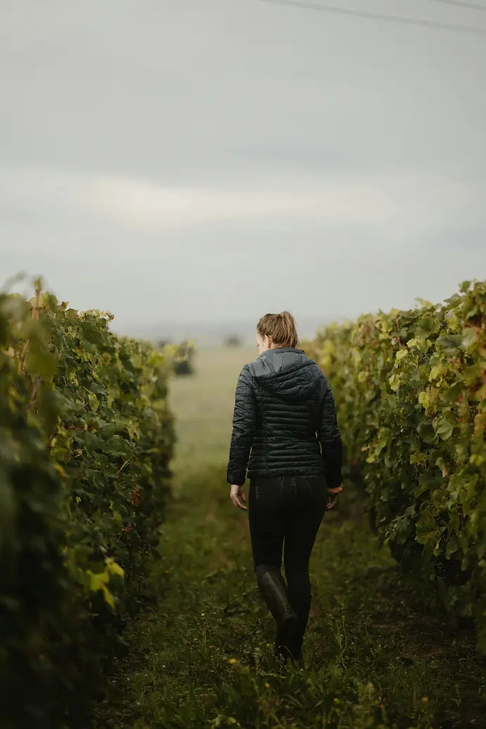 a woman walking through a lush green field